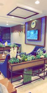 restauracja ze stołami i krzesłami z roślinami w obiekcie Swiss Blue Al Samer w mieście Dżudda