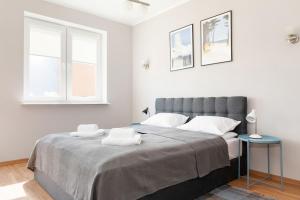 a bedroom with a large bed and a window at Spacerowa Apartments with Parking by Renters in Kołobrzeg