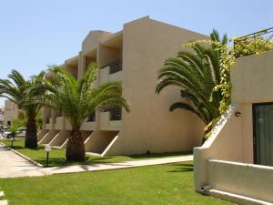 een gebouw met palmbomen ervoor bij Summerland Hotel in Ialyssos