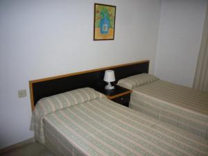ベニドルムにあるGemelos 2 - Fincas Arenaのベッドルーム1室(ベッド2台、テーブルの上にランプ付)