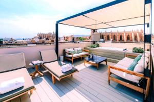 a rooftop deck with chairs and a view of a city at Sant Francesc Hotel Singular in Palma de Mallorca