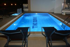 a large blue swimming pool with chairs around it at THE NORDİC HOTEL in Kemer