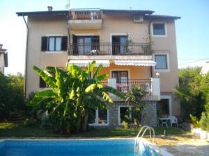 a villa with a swimming pool in front of a house at Apartman Marija in Kastav