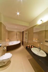 La salle de bains est pourvue d'une baignoire, de toilettes et d'un lavabo. dans l'établissement Hotel Zimnik Luksus Natury Spa & Wellness, à Szczyrk