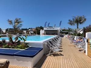 a swimming pool with lounge chairs next to a resort at Gran Hotel Flamingo-Adults Only older 18 years old in Lloret de Mar