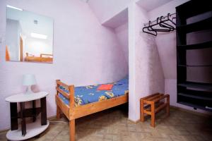 a small bedroom with a small bed and a mirror at Гостевой дом АГАТ in Omsk
