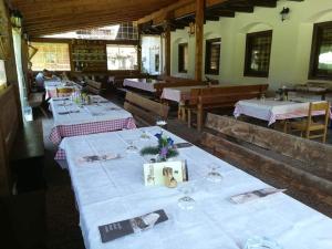 un comedor con mesas con manteles blancos en Agritur le Vale, en Fiera di Primiero