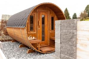 una pequeña casa hobbit de madera con puerta de madera en Ferienwohnung Relax Loft en Hallschlag