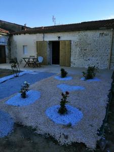 a courtyard with blue gravel and plants in front of a building at La forge in Saint-Palais-sur-Mer