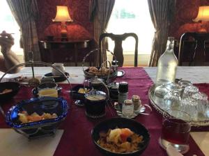 Ballyragget的住宿－Grange Manor，餐桌,带食物盘和一瓶葡萄酒