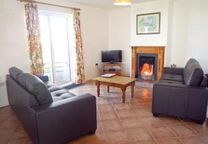 a living room with two couches and a fireplace at Ballybunion Holiday Cottages No 7 in Ballybunion