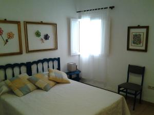 a bedroom with a bed with a window and a chair at casita bonita in Vinaròs