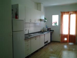 a kitchen with white cabinets and a refrigerator at casita bonita in Vinaròs