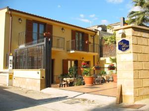 un edificio amarillo con un cartel delante en B&B Villa Rosa, en San Leone