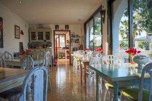un comedor con mesas y sillas blancas en Buena Idea - Adults Only en Jalón