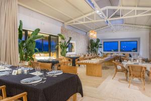 un restaurante con mesas, sillas y ventanas en Pula Golf Resort, en Son Servera