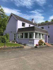 Casa blanca con porche en una calle en Glenlochy Nevis Bridge Apartments, en Fort William
