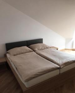 een bed met twee kussens in een slaapkamer bij Apartmán T5 Vrchlabí in Vrchlabí