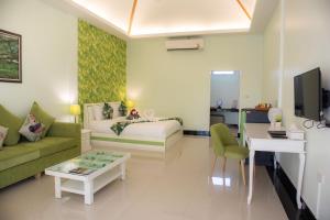 uma sala de estar com uma cama, um sofá e uma mesa em Tubtim Siam River Kwai Resort em Kanchanaburi