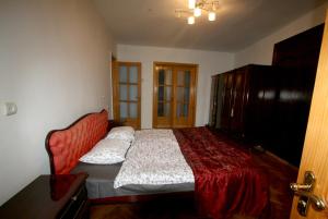 ein Schlafzimmer mit einem großen Bett mit einer roten Tagesdecke in der Unterkunft 35 Paliashvili in Kutaissi