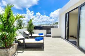 un patio con sillas y mesas en un balcón en 4BDR Pool Villa In Laguna Park #45, en Bang Tao Beach