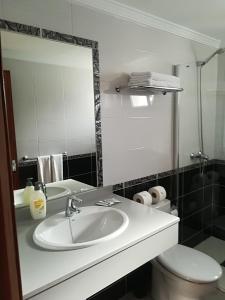 a bathroom with a sink and a toilet and a mirror at Gabiete in Puerto del Carmen