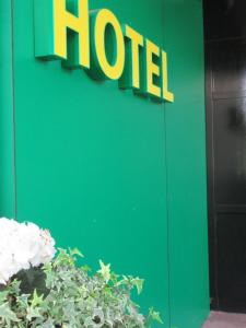 una señal de hotel en un lado de una pared verde en Hotel Stadt Gernsbach en Gernsbach