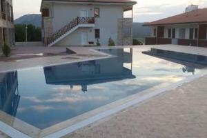 a swimming pool with a reflection of a building at İmbros House in the heart of the nature in Gokceada Town