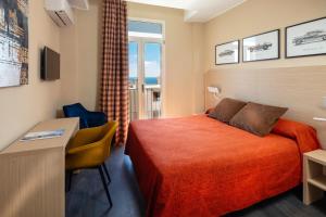 a hotel room with a bed and a desk at Hotel Miramar in Cap d'Ail +37 photos