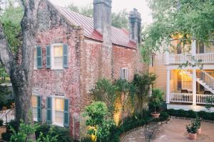 an old brick house with a porch and a patio at Zero George Hotel in Charleston