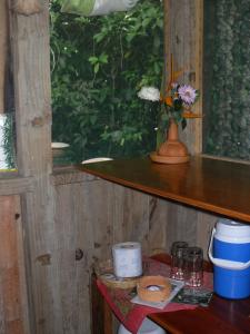 a wooden shelf with a vase of flowers on it at Reserva Ecologica Nanciyaga in Catemaco