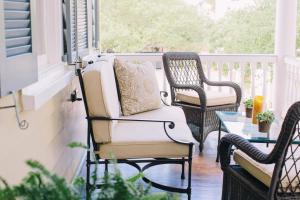 a porch with two chairs and a table at Zero George Hotel in Charleston