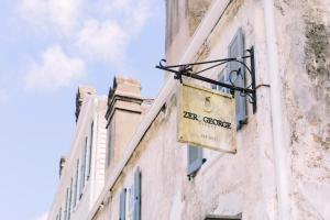 a sign hanging on the side of a building at Zero George Hotel in Charleston