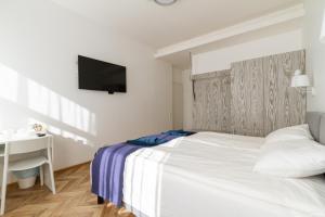 a bedroom with a bed and a desk and a television at Hot Spot Vilnius Apartments in Vilnius