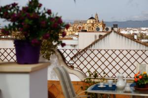 un balcón con una mesa y un jarrón de flores en La Casa del Río en Córdoba
