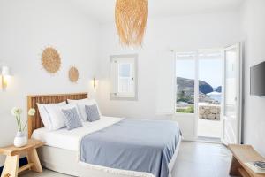 a white bedroom with a bed and a window at Milos Breeze Boutique Hotel in Pollonia +37 photos