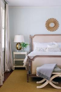 a bedroom with a bed with a gold mirror on the wall at Zero George Hotel in Charleston