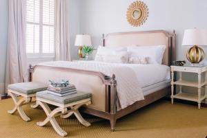 a bedroom with a bed and a chair and a mirror at Zero George Hotel in Charleston