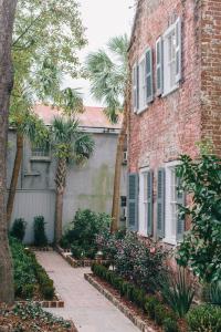a brick building with a palm tree next to a sidewalk at Zero George Hotel in Charleston