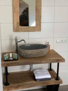 y baño con lavabo de piedra sobre una mesa de madera. en Brasserie de Peperboom, en Veere