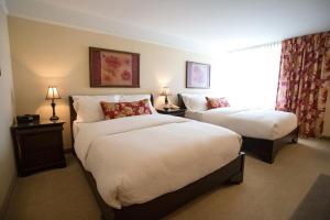 a hotel room with two beds and a window at Hotel Vallea Bromont in Bromont