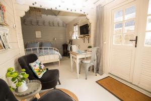 a room with a bed and a table and chairs at Landelijk logeren bij De Witte Kip in 't Harde