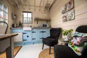 a kitchen with blue cabinets and two chairs in a room at Landelijk logeren bij De Witte Kip in 't Harde