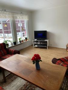 una sala de estar con un jarrón de flores sobre una mesa en Four Bedroom Guesthouse in Fjerdingen, Harran, en Grong