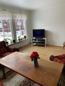 a living room with a vase of flowers on a table at Four Bedroom Guesthouse in Fjerdingen, Harran in Grong