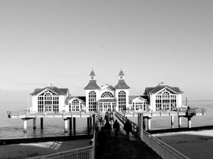 ein schwarz-weißes Foto eines Gebäudes auf einem Pier in der Unterkunft Ferienhaus - Weißer Steg Sieben in Ostseebad Sellin