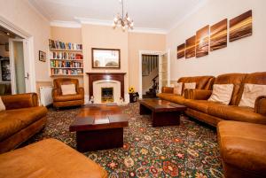 a living room with brown furniture and a fireplace at Hambledon Hotel in Shanklin
