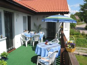 eine Terrasse mit einem Tisch und einem Sonnenschirm in der Unterkunft Haus am Haff in Karnin