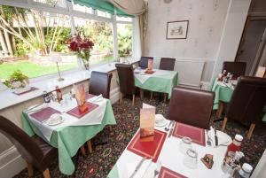 a restaurant with tables and chairs and a window at Hambledon Hotel in Shanklin