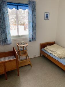 a bedroom with two beds and a chair and a window at Four Bedroom Guesthouse in Fjerdingen, Harran in Grong